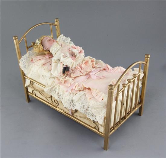 An early 20th century Austrian child in a bed musical automaton, length 14in.
